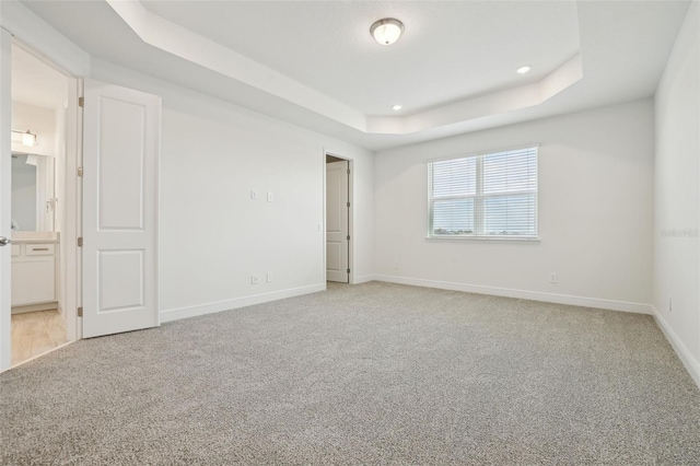 16354 Silver Grove Blvd, Winter Garden, FL 34787 - unfurnished bedroom featuring a raised ceiling, light carpet, baseboards, recessed lighting, and ensuite bathroom