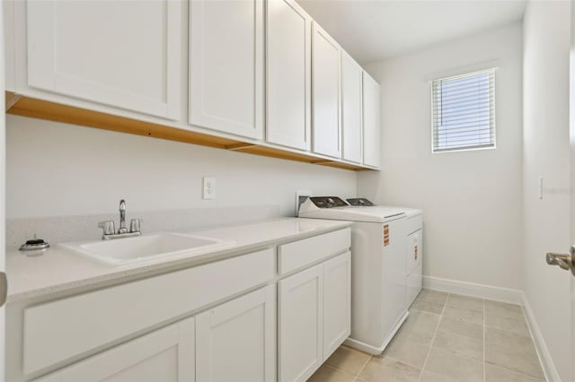 16354 Silver Grove Blvd, Winter Garden, FL 34787 - laundry area with cabinet space, baseboards, washer and clothes dryer, and light tile patterned flooring
