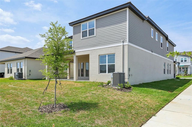 16354 Silver Grove Blvd, Winter Garden, FL 34787 - back of house with central AC unit, a yard, and stucco siding
