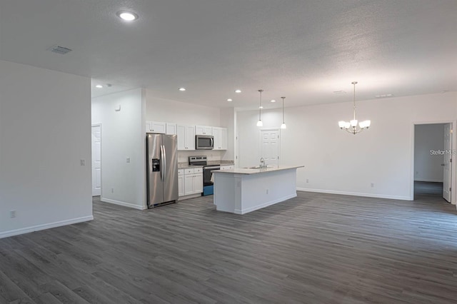 kitchen featuring a sink, stainless steel appliances, open floor plan, and white cabinets