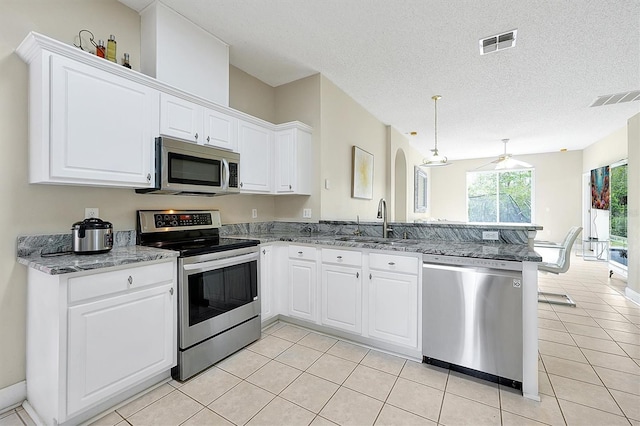 kitchen with a sink, stainless steel appliances, visible vents, and a peninsula