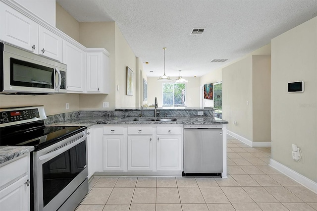 kitchen with visible vents, light tile patterned floors, appliances with stainless steel finishes, a peninsula, and a sink