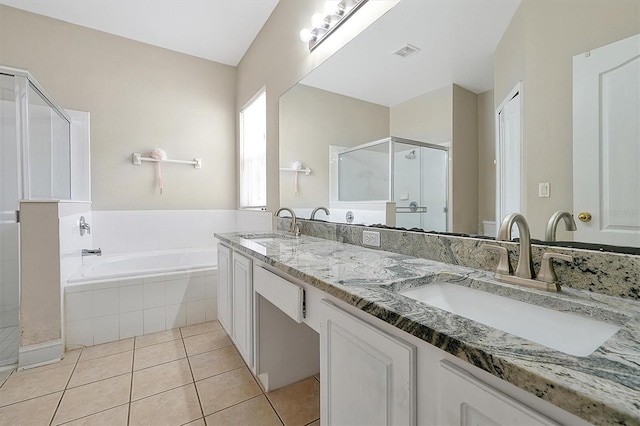 bathroom featuring a shower stall, a garden tub, tile patterned floors, and a sink