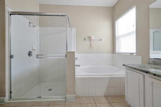 bathroom featuring tile patterned floors, a shower stall, a bath, and vanity