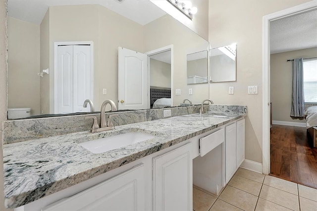 bathroom with tile patterned flooring, ensuite bathroom, and a sink