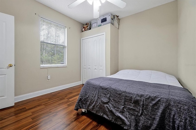 bedroom featuring a ceiling fan, wood finished floors, baseboards, and a closet