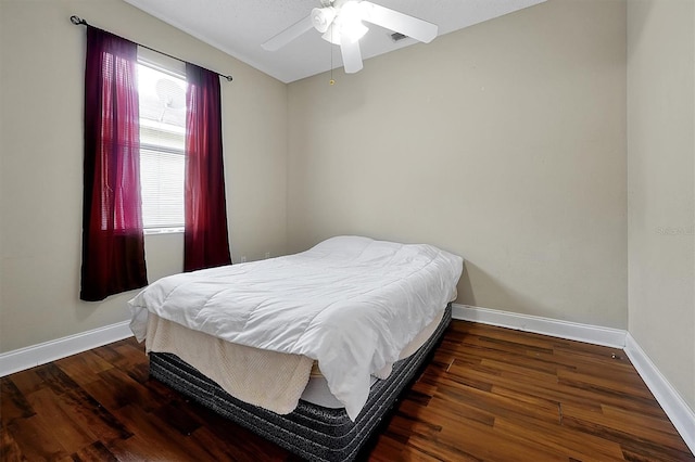 bedroom with baseboards, wood finished floors, and a ceiling fan