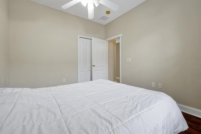 bedroom with visible vents, ceiling fan, baseboards, wood finished floors, and a closet