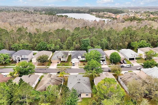 drone / aerial view featuring a residential view, a forest view, and a water view