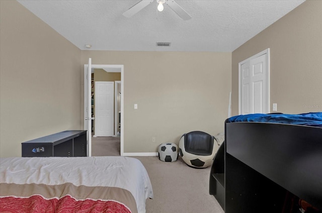 bedroom featuring visible vents, a ceiling fan, a textured ceiling, carpet flooring, and baseboards