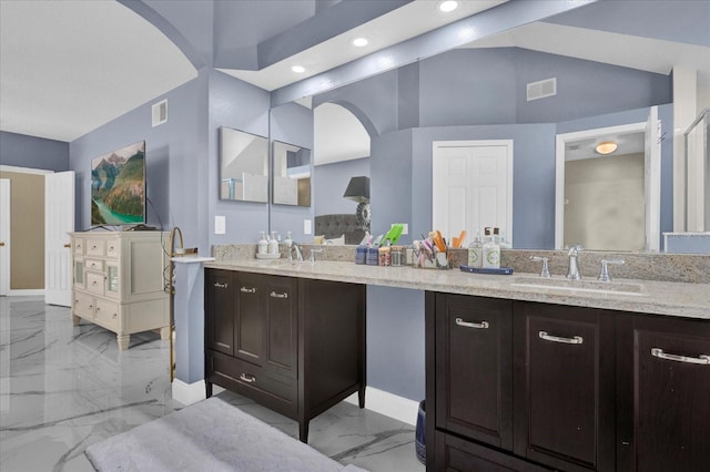 bathroom featuring vanity, lofted ceiling, visible vents, and marble finish floor