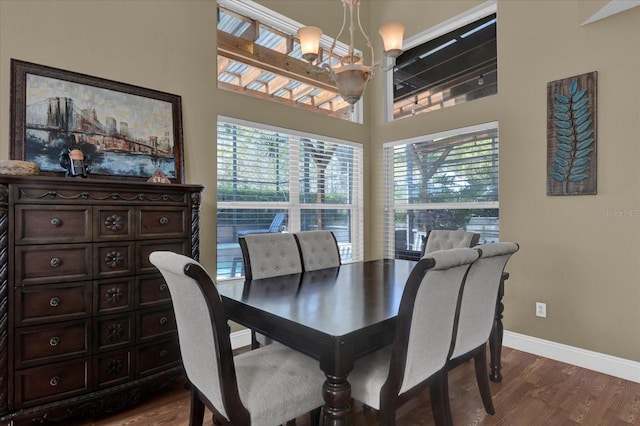 dining room featuring a chandelier, baseboards, and dark wood-style flooring