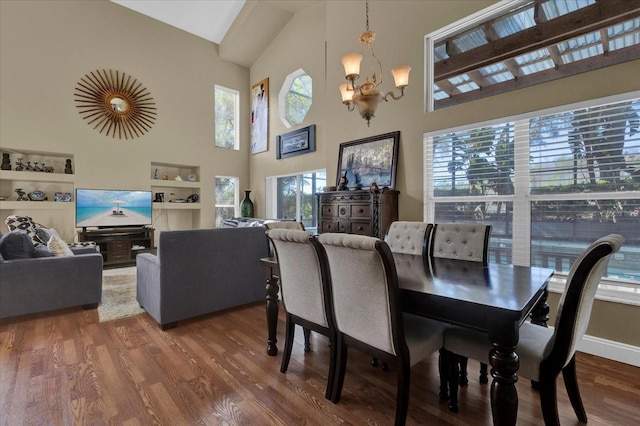 dining space with a chandelier, high vaulted ceiling, and wood finished floors