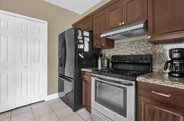 kitchen featuring tasteful backsplash, under cabinet range hood, light tile patterned floors, stainless steel range with electric cooktop, and black fridge with ice dispenser