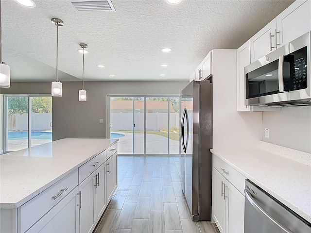 kitchen featuring pendant lighting, visible vents, appliances with stainless steel finishes, and white cabinets