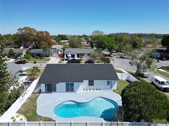 view of swimming pool featuring a fenced in pool, a residential view, a fenced backyard, and a patio area