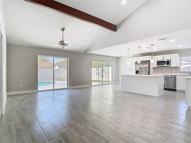 unfurnished living room with visible vents, baseboards, lofted ceiling with beams, light wood-style flooring, and a ceiling fan