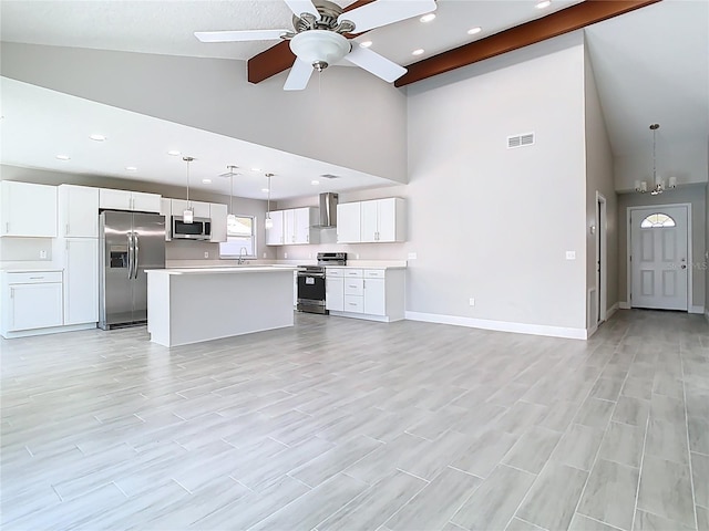 kitchen with baseboards, wall chimney range hood, open floor plan, light countertops, and stainless steel appliances