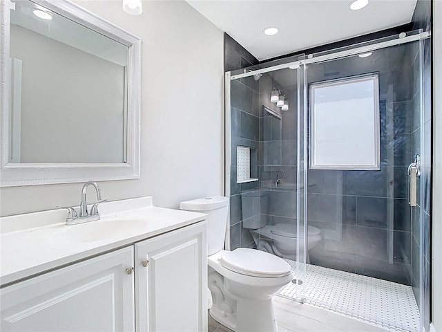 bathroom featuring vanity, a shower stall, and toilet