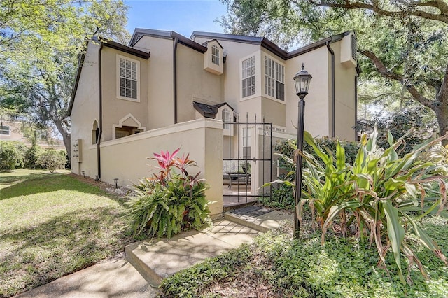 view of front facade with a fenced front yard, stucco siding, and a front lawn