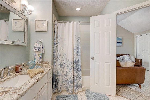 full bathroom featuring a textured ceiling, vanity, lofted ceiling, and shower / bathtub combination with curtain