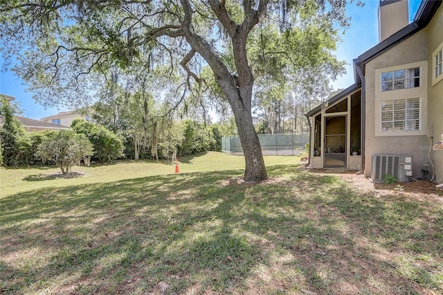 view of yard with central AC and fence