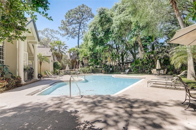 community pool featuring a patio area and fence