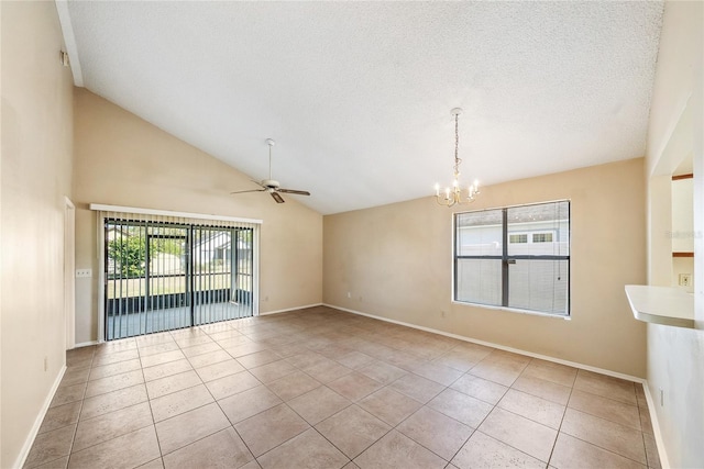 tiled spare room featuring a wealth of natural light, ceiling fan with notable chandelier, and a textured ceiling