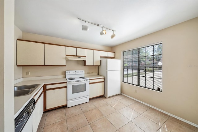 kitchen with under cabinet range hood, a sink, white appliances, light countertops, and light tile patterned floors