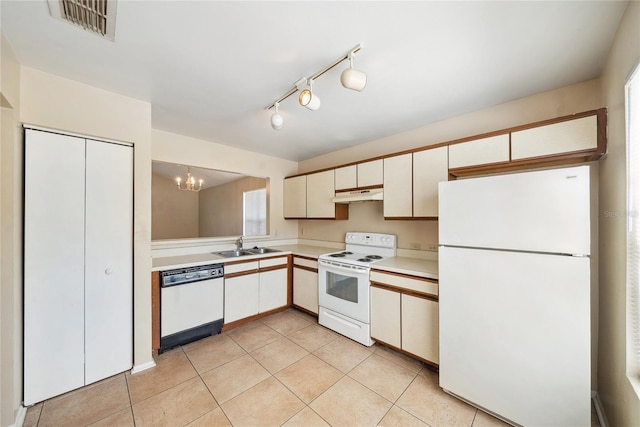 kitchen with visible vents, under cabinet range hood, light countertops, white appliances, and a sink