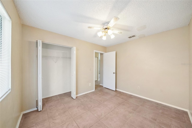 unfurnished bedroom with baseboards, visible vents, ceiling fan, a closet, and a textured ceiling