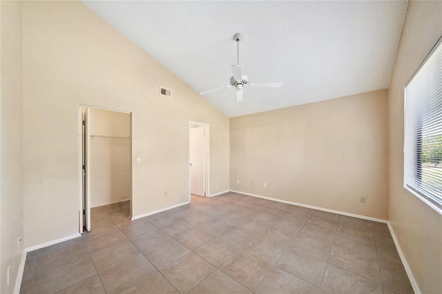 unfurnished bedroom featuring light tile patterned floors, a ceiling fan, baseboards, visible vents, and a walk in closet