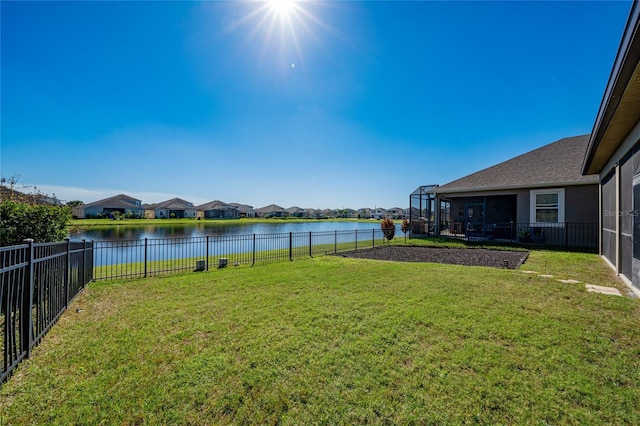 view of yard featuring a lanai, a fenced backyard, a water view, and a residential view