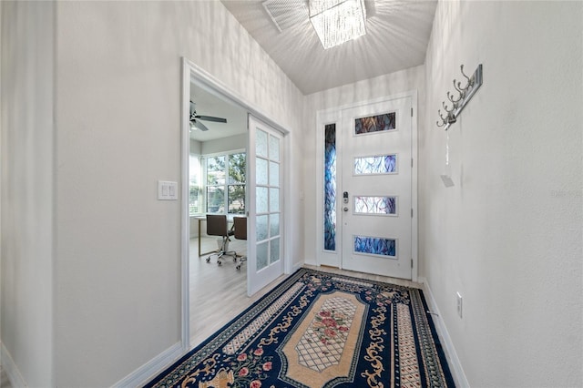 doorway featuring a notable chandelier, baseboards, and wood finished floors