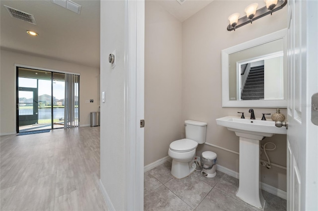 bathroom with tile patterned floors, visible vents, baseboards, and toilet