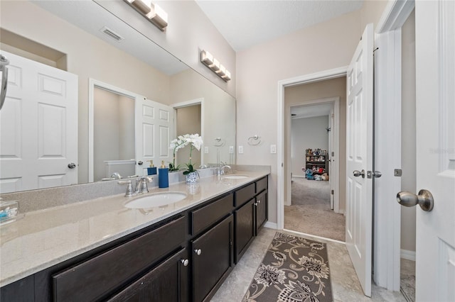 bathroom featuring double vanity, visible vents, baseboards, and a sink