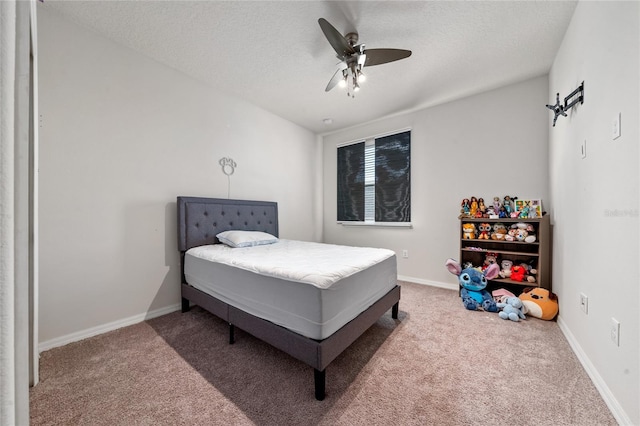 carpeted bedroom featuring a ceiling fan, baseboards, and a textured ceiling