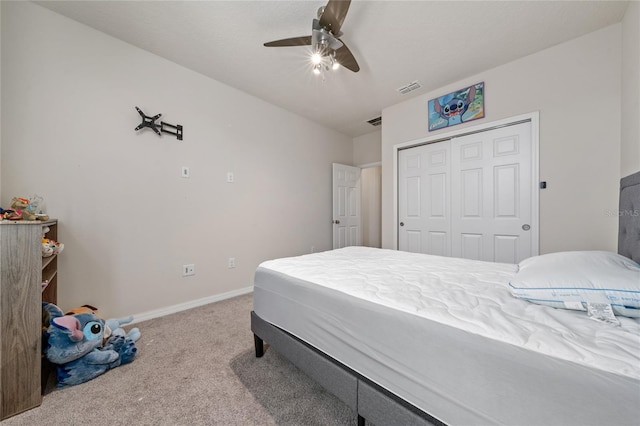 carpeted bedroom with visible vents, baseboards, a closet, and a ceiling fan