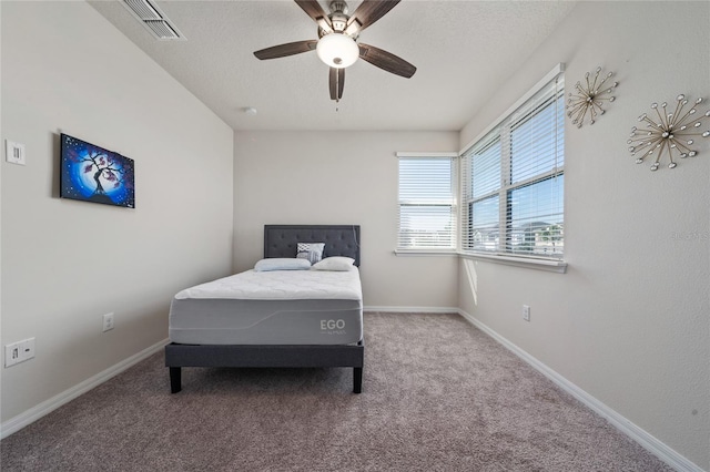 bedroom with visible vents, baseboards, carpet, and a textured ceiling