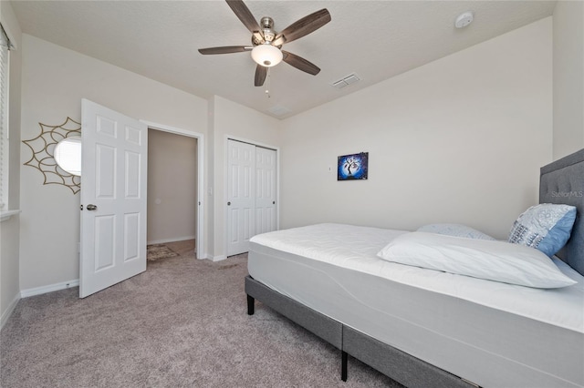 carpeted bedroom with a ceiling fan, baseboards, visible vents, and a closet