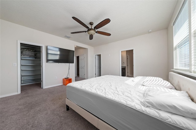 bedroom featuring visible vents, baseboards, multiple closets, carpet flooring, and a textured ceiling