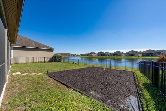 view of yard featuring a fenced backyard, a water view, and a residential view