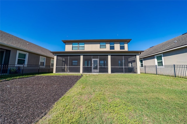 rear view of house with stucco siding, a lawn, fence private yard, and a sunroom