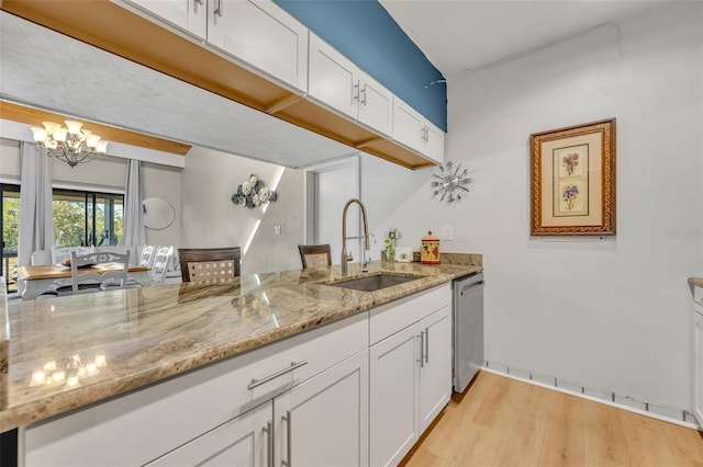 kitchen featuring dishwasher, white cabinetry, an inviting chandelier, and a sink