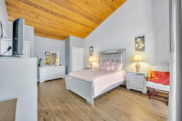 bedroom featuring a closet, wooden ceiling, light wood-style floors, and lofted ceiling