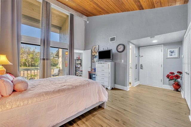 bedroom featuring visible vents, wood finished floors, wooden ceiling, baseboards, and access to exterior