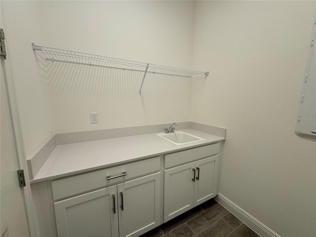 laundry area featuring a sink and baseboards