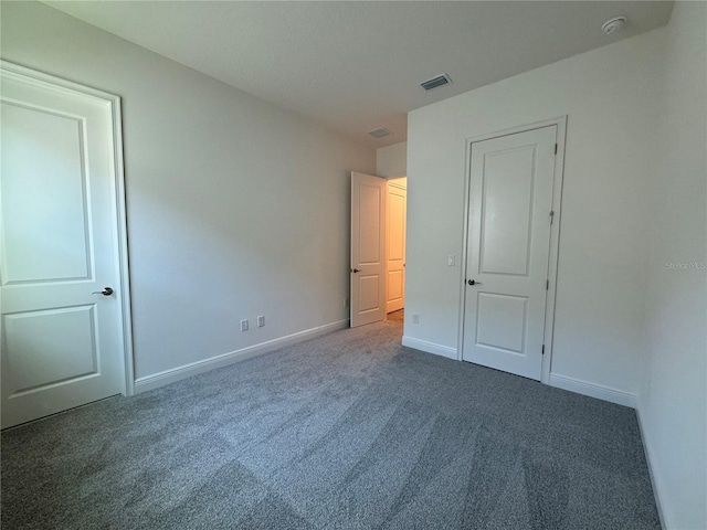 unfurnished bedroom featuring carpet flooring, baseboards, and visible vents