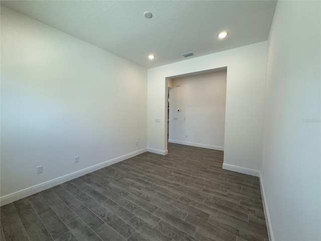 spare room featuring recessed lighting, visible vents, baseboards, and dark wood finished floors