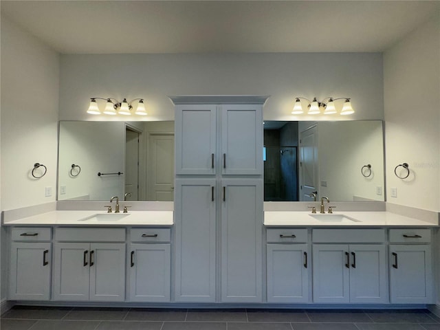 full bath featuring a sink, two vanities, and a stall shower